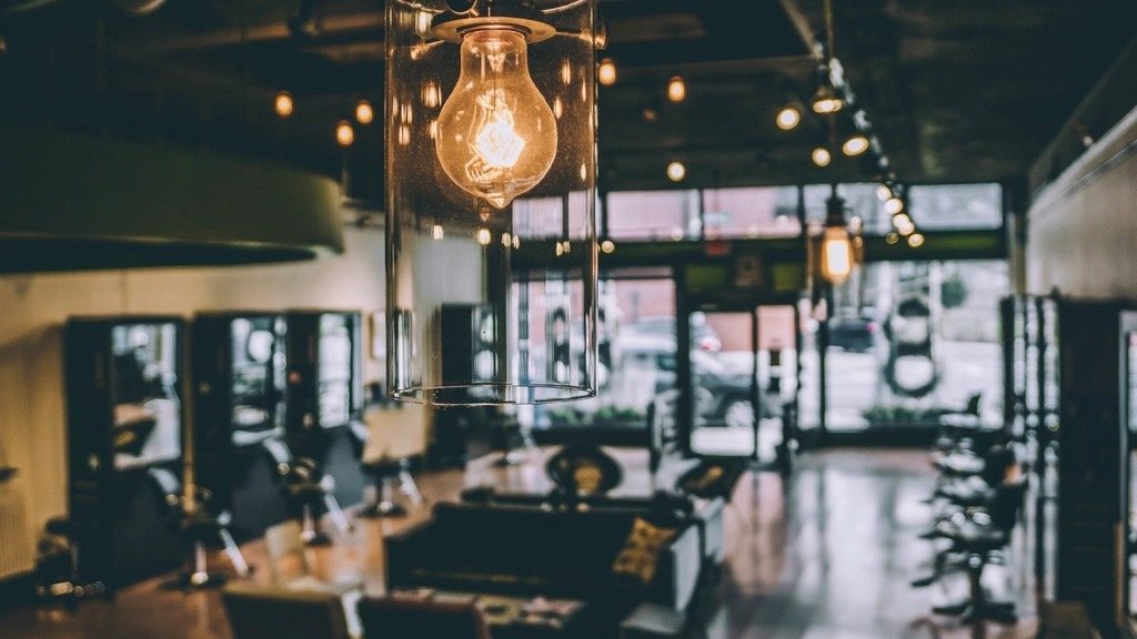 Interior de la barbería con sillones y focos cálidos