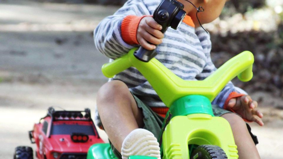 Niño pequeño jugando en su triciclo