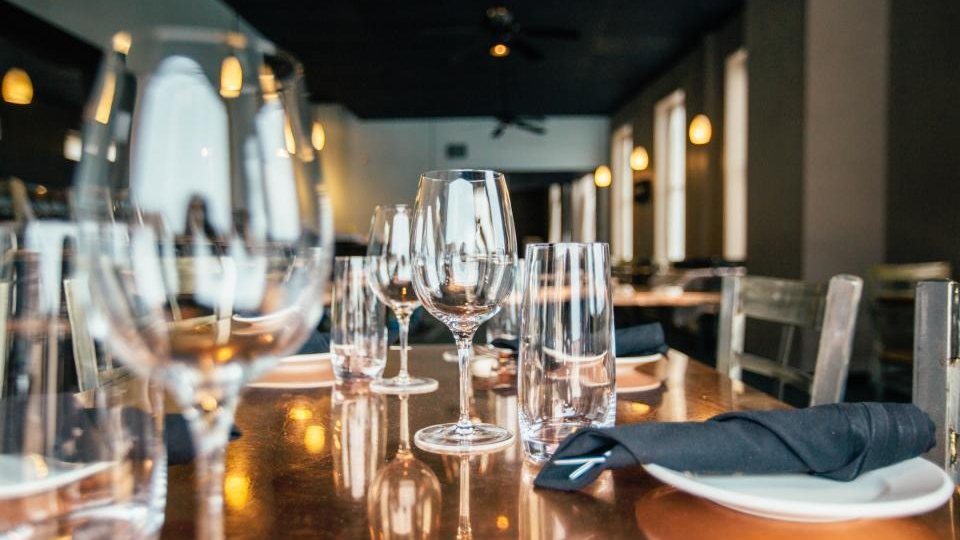 Mesa puesta con copas y servicio en el salón del restaurante